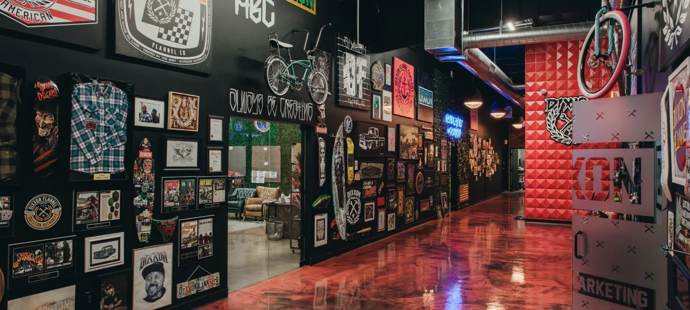Inside the Dixxon showroom: framed flannels on black walls and a polished red floor.